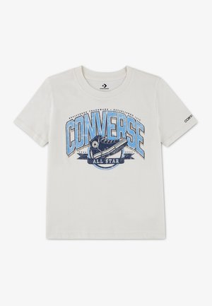Biała koszulka z krótkim rękawem z dużym niebieskim logo Converse All Star i grafiką czarnego buta Converse w środku.