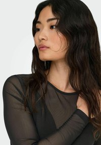 Black mesh long-sleeve top with a round neckline. Features sheer textured sleeves and a fitted silhouette, emphasizing lightweight fabric.