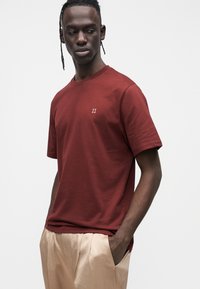 Bordowa koszulka z krótkim rękawem wykonana z bawełny, z małym białym logo "II" na lewej piersi. Prosty krój i gładka faktura.