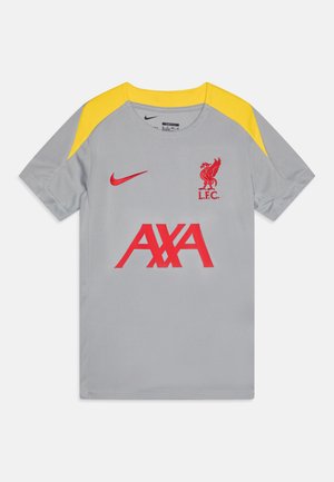 Maglia sportiva grigia con accenti gialli sulle spalle, caratterizzata da un logo rosso del Liverpool FC e la scritta "AXA" in rosso sul davanti. Logo Nike sul petto.