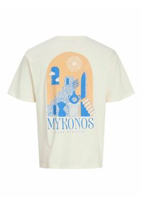 Kreminės spalvos medvilninė marškinė su mėlynos ir oranžinės spalvos grafiniu dizainu, vaizduojančiu laiptus, debesis ir vazą su augalu. Tekstas skelbia: "MYKONAS – ŠVARUS ROJUS."