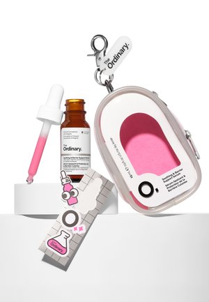 Clear container with a pink inner shape, an amber glass dropper bottle, and colorful stickers featuring cartoon images and logos.