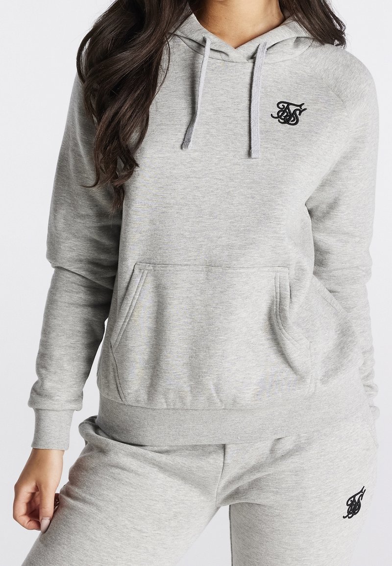 Sweat à capuche gris en tissu mélange de coton, avec une poche frontale, une capuche à cordon de serrage et un logo noir sur la poitrine. Texture douce.