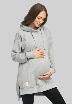 Grauer Umstandshoodie mit lockerer Passform, Kordelzugkapuze, seitlichen Schlitzen und einem strukturierten Stoff. Mit einem Markenetikett auf der Vorderseite.