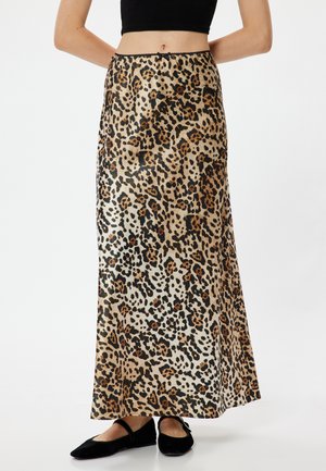 Jupe maxi en tissu satiné imprimé léopard, avec une taille haute et un design fluide. Les couleurs incluent des accents beige, noir et marron.