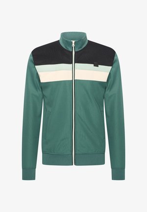Veste zippée verte avec col montant, panneau noir sur les épaules et rayures blanches sur la poitrine. Fabriquée en tissu texturé, avec deux poches.