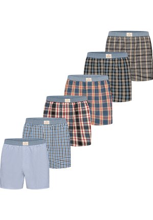 Sei paia di boxer da uomo in vari motivi a quadri e righe con elastici blu in vita, disposti in una linea diagonale.
