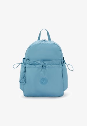 Zaino blu chiaro con design arrotondato, chiusura a cappuccio, cordoncino regolabile, tasche laterali e una badge del logo sulla parte anteriore.