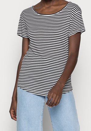 Stribet t-shirt i sort og hvid med rund halsudskæring, korte ærmer og løs pasform, parret med lys blå vide bukser.