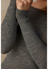 Šedý žebrovaný dlouhý rukáv s měkkou texturou a přiléhavými rukávy, s off-shoulder dekoltem.