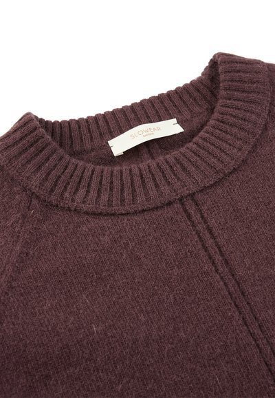 Maglione viola scuro con scollatura a costine e una sottile texture. Presenta un'etichetta attaccata al colletto con il marchio "SLOWEAR".