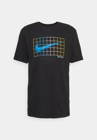 Camiseta de algodón negra con el logotipo de Nike en forma de swoosh azul sobre una cuadrícula amarilla y azul, con el texto "JUST DO IT" debajo.