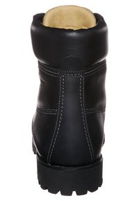Botín de tobillo negro de cuero con punta redondeada, costuras en contraste, cuello acolchado y suela de goma texturizada. Interior forrado con material crema.