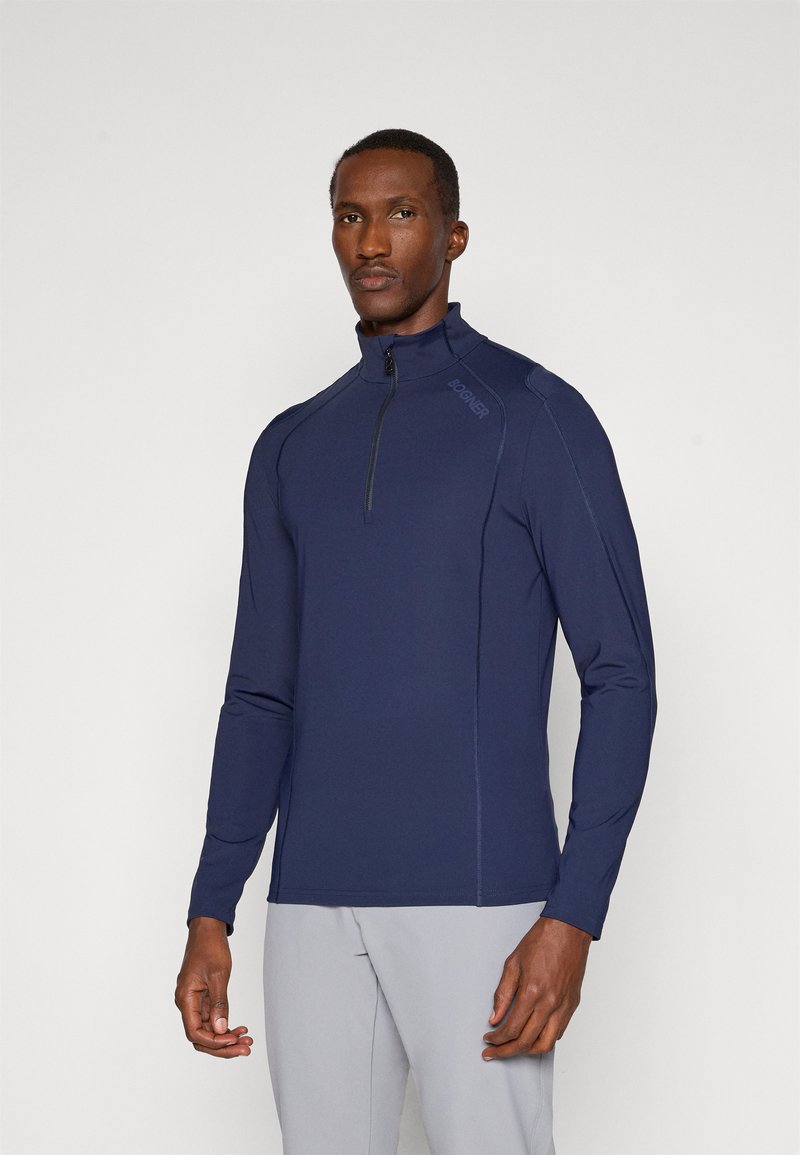 Marineblå langermet zip-up skjorte med høy krage, med kontrastsying og logo på skulderen. Glatt, lett stoff.