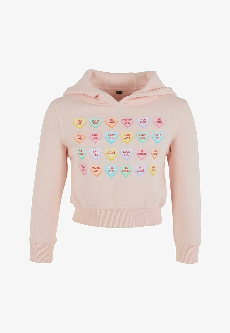 Izgriezta rozā kapucīte ar mīkstu tekstūru, kuras priekšpusē ir cicējošas pastelkrāsas sirds grafikas ar dažādiem uzrakstiem.