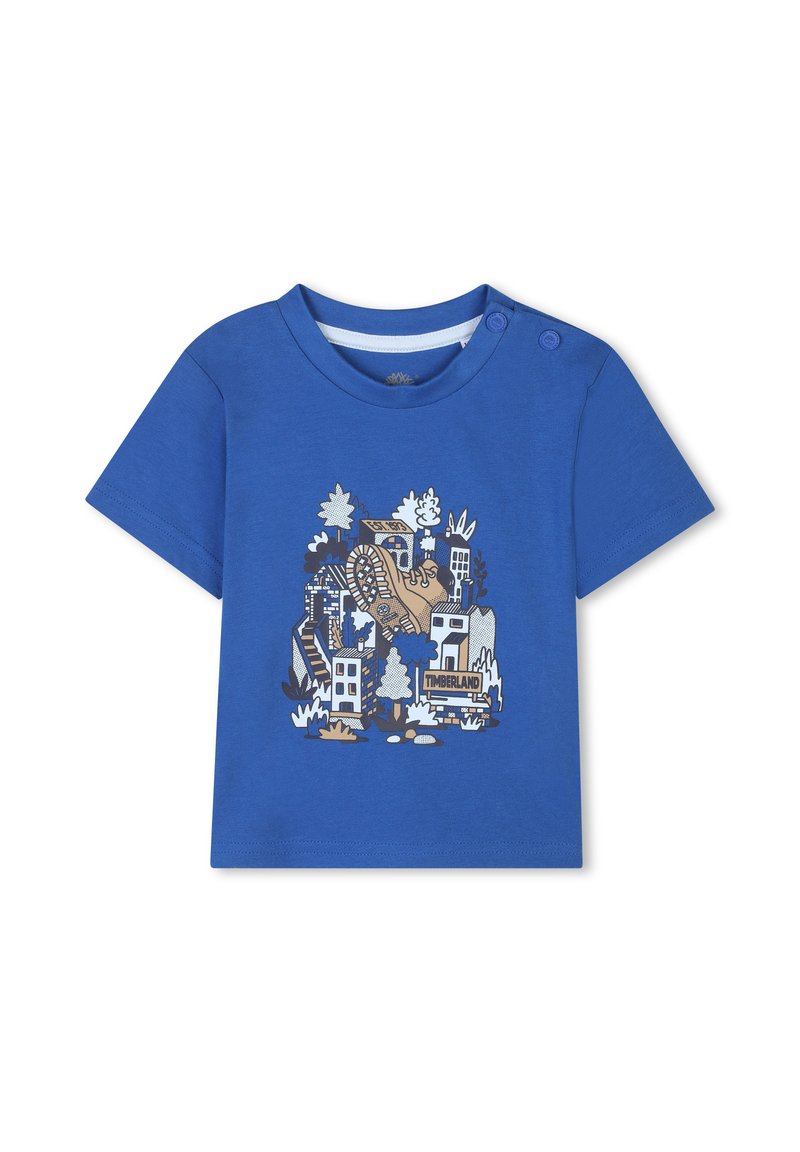Blauwe T-shirt met korte mouwen van katoen, met een grafische print van een laars en gebouwen, en knopen op de schouder voor gemakkelijke aan- en uittrekken.