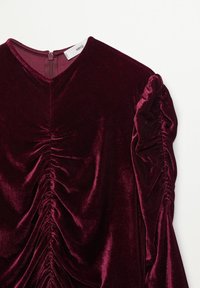 Bordeaux sametový top s výstřihem do V, s nabíranými detaily vpředu a balónovými rukávy. Zapínání na zip na zadní straně.