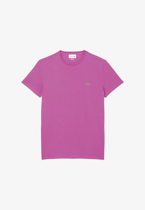 T-shirt a maniche corte in cotone rosa vivace con scollatura tonda e un piccolo logo Lacoste verde sul lato sinistro del petto.
