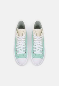 Zapatillas altas de lona verde menta con acentos crema. Cordones blancos y suelas de goma. Presentan una puntera redondeada y detalles cosidos.