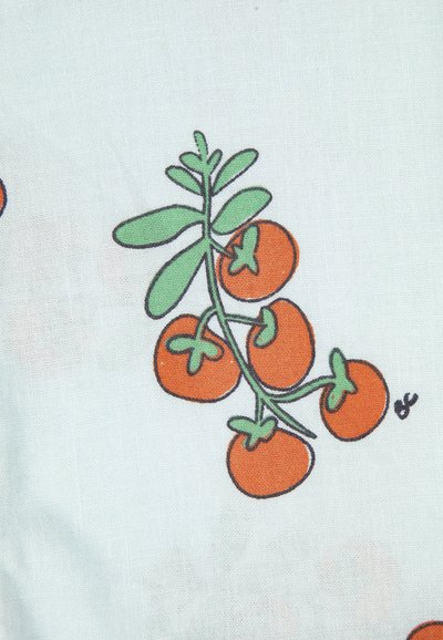 Grappe de cinq tomates cerises stylisées orange avec des tiges et des feuilles vertes sur un fond de tissu clair.