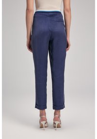 Pantaloni in lino blu navy con vestibilità slim, caratterizzati da un orlo arrotolato e una vita di un blu chiaro a contrasto, progettati con due tasche posteriori.