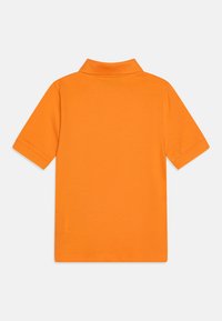 Oransje polo skjorte i myk bomull, med krage, korte ermer og en ensfarget tekstur uten mønstre eller aksenter.