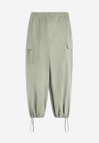 Pantaloni cargo verde chiaro realizzati in tessuto morbido, con polsini elasticizzati, due tasche laterali e una vestibilità comoda con regolazione tramite cordoncino.