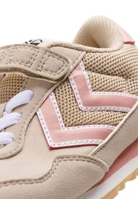 Beiga mocka sneakers med rosa och vita accenter, nätpanelen och ett kardborreband. Har vita snören och en texturerad gummisula.