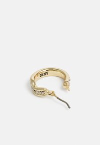 Gulløkt earring som har en buet design med klare edelstener på den ene siden og en hengslet lukking for å feste. Merket "DKNY" på innsiden.