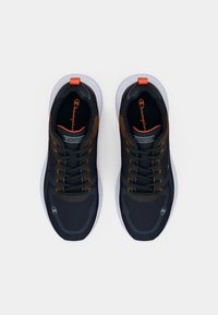 Mustat urheilukengät oransseilla yksityiskohdilla, verkkomateriaali, pyöreä nilkka ja valkoinen pohja. Varustettu nauhakiinnityksellä ja logolla sivussa.