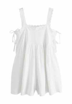 Witte mouwloze peuterjurk met kanten aanzet, voorste plooidetails en zijstrikjes op een effen achtergrond.