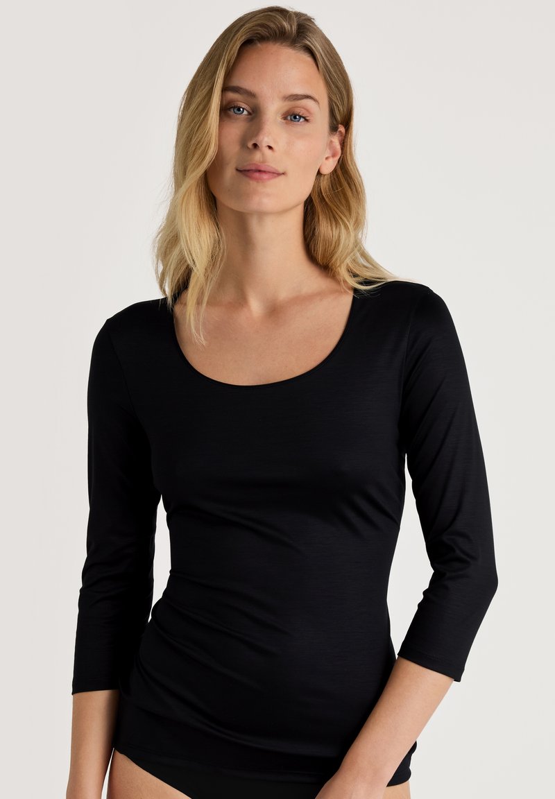 Zwarte longsleeve top met een ronde hals. Gemaakt van gladde, lichtgewicht stof, met een getailleerde pasvorm en zonder zichtbare patronen.