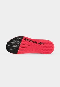 Σόλα από κόκκινο και μαύρο παπούτσι Reebok με υφή για καλύτερη πρόσφυση και το λογότυπο Reebok σε μαύρο στο κόκκινο τμήμα.