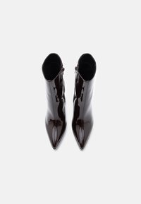 Μαύρες παπούτσια αστραφτερής δέρματος με μυτερή μύτη και κομψό φινίρισμα. Διαθέτουν φερμουάρ στο πλάι για κλείσιμο. Ομαλή υφή σε όλη την επιφάνεια.