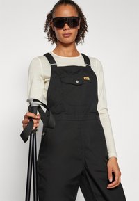 Fjällräven VARDAG DUNGAREE TROUSERS W - Hlače za na prostem - black