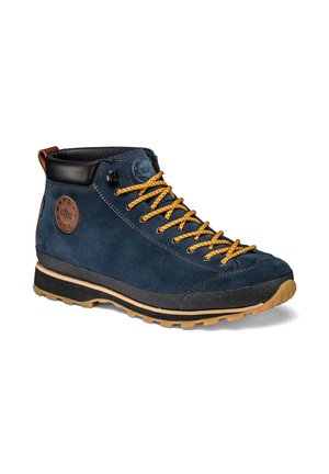 Navy blue suede hiking boot with yellow laces, black padded collar, brown pull tab, and textured tan rubber sole.