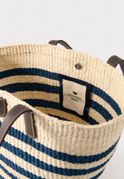 Sac cabas en paille tressée avec des rayures horizontales bleu marine, poignées en cuir marron et une étiquette intérieure en tissu indiquant « Weekend Max Mara ».