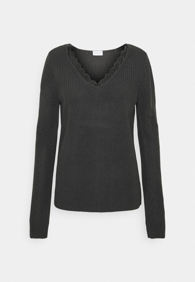 Svart stickad tröja med långa ärmar, V-ringning och scallopkant längs ringningen. Medelvikts och texturerat tyg.