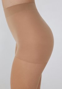 Przezroczyste, beżowe szorty modelujące z szerokim, gładkim pasem. Materiał jest miękki i elastyczny, zaprojektowany z myślą o komforcie i bezszwowym wyglądzie.