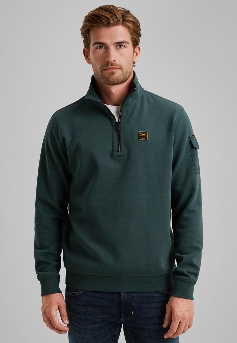 Green fleece sweatshirt with a high collar, half zipper, and a logo patch on the chest. Features ribbed cuffs and hem, and a sleeve pocket.