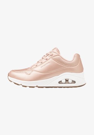Zapatilla deportiva en rosa dorado con parte superior de cuero suave, acentos perforados, mediopie blanco y detalle de amortiguación de aire transparente.