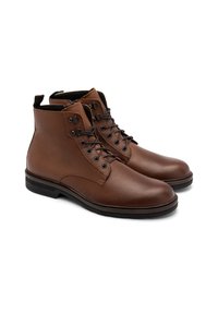 Brązowe skórzane botki za kostkę z teksturowanym wykończeniem, okrągłym noskiem, wzorzystymi sznurowadłami, oczkami i bocznym uchwytem. Gumowa podeszwa zapewniająca przyczepność.