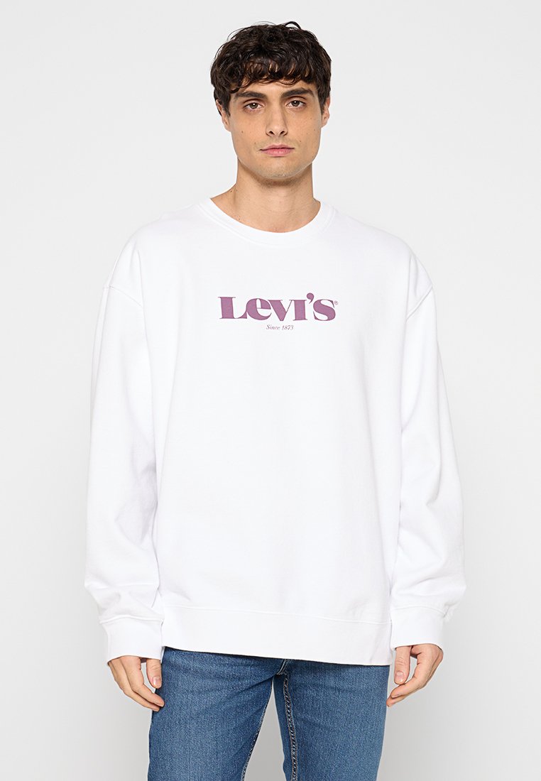Sudadera blanca de manga larga, con un logo de Levi's en color púrpura y el texto "Desde 1873". Ajuste holgado y puños acanalados en las muñecas.