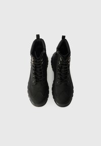 Melnas augstās kedas ar teksturētu ādu, aukliņu priekšpusi, mīkstu apkakli un gumijas zoli ar viļņveida protektoru.