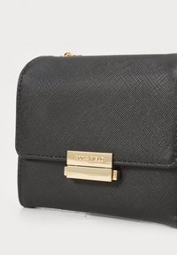 Black textured clutch bag with a rectangular shape, featuring a gold-tone clasp and branding, suitable for formal occasions.