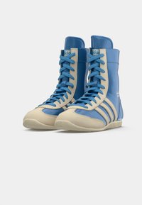 Blue and cream high-top athletic shoes featuring a smooth leather upper, three white stripes, and textured rubber sole.