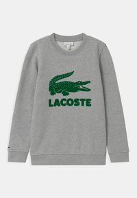 Szara bluza wykonana z mieszanki bawełny, z zielonym logo krokodyla i napisem "LACOSTE". Mankiety i dół bluzy wykończone ściągaczem, okrągły dekolt.