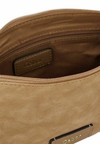 Borsa in pelle marrone chiaro con una finitura liscia e testurizzata. Caratterizzata da una chiusura con zip e un'etichetta con il marchio all'interno. Design compatto e funzionale.