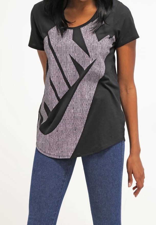 Svart t-shirt med kort ärm och en stor, vertikal vit Nike-logotypdesign, med randig struktur och rundad fåll. Bärs med blå jeans.