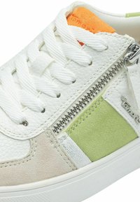 Baskets blanches avec des accents en cuir texturé et en daim de couleur menthe et beige. Fermeture éclair latérale notable et semelle intérieure orange contrastante.